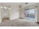 Bright living room with a ceiling fan, neutral carpet, and access to a patio at 8600 W Charleston Blvd # 1128, Las Vegas, NV 89117
