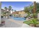 Backyard featuring a pool with a rock waterfall, covered patio, and lush landscaping at 928 Aspen Valley Ave, Las Vegas, NV 89123