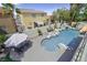 Backyard pool area with rock waterfall feature, palm trees, and seating area at 928 Aspen Valley Ave, Las Vegas, NV 89123