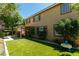 Exterior view showcasing the backyard with artificial grass and covered patio with outdoor seating at 10744 Balsam Creek Ave, Las Vegas, NV 89144