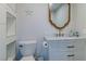 Bathroom features vanity with marble countertop, framed mirror, decorative starfish, and built-in shelving at 10744 Balsam Creek Ave, Las Vegas, NV 89144
