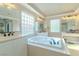 Bright bathroom featuring a large soaking tub, dual vanities, and neutral color palette at 10744 Balsam Creek Ave, Las Vegas, NV 89144