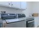 Updated laundry room with modern washer and dryer units, sink, and plenty of counter space at 10744 Balsam Creek Ave, Las Vegas, NV 89144