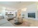 Bright living room featuring a fireplace and open floor plan leading to modern kitchen at 10744 Balsam Creek Ave, Las Vegas, NV 89144