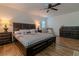 Spacious main bedroom features dark wood accents, hardwood flooring, and a ceiling fan at 10744 Balsam Creek Ave, Las Vegas, NV 89144