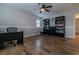 Spacious office with hardwood floors, black built-in bookcases, and an elegant ceiling fan with light at 10744 Balsam Creek Ave, Las Vegas, NV 89144