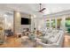 Bright living room with stone fireplace, ceiling fan, and french doors to outside at 11 Misty Peaks Ct, Las Vegas, NV 89135