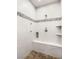 Modern shower featuring a bench seat and sleek design with white tile and brown floor at 11 Misty Peaks Ct, Las Vegas, NV 89135