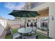 Outdoor dining set under an umbrella on artificial grass backyard at 1101 Elation Ln # 2, Henderson, NV 89002