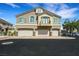 Three-car garage townhome with a stylish exterior, neutral color palette, and well-manicured surroundings at 1101 Elation Ln # 2, Henderson, NV 89002