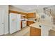 Well-lit kitchen featuring wooden cabinetry, white appliances, and a breakfast bar at 1101 Elation Ln # 2, Henderson, NV 89002