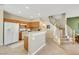 Open kitchen with wood cabinets, tiled flooring, breakfast bar, and staircase to the upper level at 1101 Elation Ln # 2, Henderson, NV 89002
