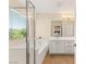 Bright bathroom featuring a soaking tub, glass shower, vanity with sink and tile floors at 11226 Kenyan Sunshine Ct, Las Vegas, NV 89138