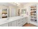 Spacious bathroom featuring double sinks, white cabinets, and a linen closet with shoe organizer providing ample storage at 11226 Kenyan Sunshine Ct, Las Vegas, NV 89138