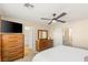 Bright bedroom with a ceiling fan, wooden dressers, and ensuite bathroom access offering comfort and convenience at 11226 Kenyan Sunshine Ct, Las Vegas, NV 89138