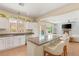 Well-lit kitchen with a granite countertop island, white cabinetry, and a view of the backyard pool at 11226 Kenyan Sunshine Ct, Las Vegas, NV 89138