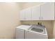 Laundry room featuring white washer and dryer with storage cabinets above at 11226 Kenyan Sunshine Ct, Las Vegas, NV 89138