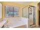 Bathroom featuring a soaking tub, separate glass shower, and window at 1128 Galangate Ave, Henderson, NV 89015