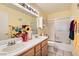 Bright bathroom features a double sink vanity and a shower over tub combo at 1128 Galangate Ave, Henderson, NV 89015