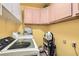 The laundry room is equipped with a modern washer and dryer, overhead cabinets, and ample storage space at 1128 Galangate Ave, Henderson, NV 89015