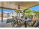 Enjoy outdoor dining on the covered patio with a ceiling fan and a view of the green backyard at 1128 Galangate Ave, Henderson, NV 89015