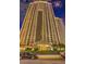 Exterior shot of a modern high-rise building at night with manicured landscaping and a beautiful front entrance at 145 E Harmon Ave # 919, Las Vegas, NV 89109