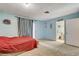 A bedroom with blue walls, carpeted floor, and an ensuite bathroom, providing a private retreat at 1847 Stevens St, Las Vegas, NV 89115