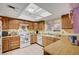 Functional kitchen with wooden cabinets, white appliances, and a bright skylight at 1847 Stevens St, Las Vegas, NV 89115