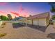 Extended backyard with gravel landscaping, covered patio and clear view of sunset at 234 Geronimo Ct, Henderson, NV 89074