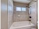 Close-up of a bath and shower combo with beige tile surround and window at 234 Geronimo Ct, Henderson, NV 89074