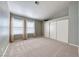 Large carpeted bedroom featuring dual windows and a closet with sliding doors at 234 Geronimo Ct, Henderson, NV 89074