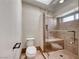 Bathroom featuring a white toilet and a glass enclosed tile shower with seat and shower niche at 234 Geronimo Ct, Henderson, NV 89074