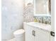 Elegant powder room featuring marble countertops, stylish fixtures, and decorative tile accent wall at 2429 Worchester Rd, Henderson, NV 89074