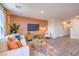 Relax in the stylish living room with plush seating, TV, and warm wood-style flooring at 2510 Petunia Garden St # 227, North Las Vegas, NV 89081
