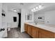 Bright bathroom featuring a wood vanity with double sinks and a walk-in shower at 2661 Ruthe Duarte Ave, Las Vegas, NV 89121