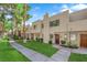 Townhouse exterior featuring a sidewalk, manicured lawn, desert landscaping and mature trees at 2661 Ruthe Duarte Ave, Las Vegas, NV 89121
