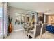 Modern dining area featuring stylish chandelier, glass table and views into the bright kitchen at 2806 Calle Cadiz, Henderson, NV 89044