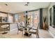 Modern dining area featuring stylish chandelier, glass table and views into the bright kitchen at 2806 Calle Cadiz, Henderson, NV 89044