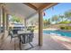 Inviting covered back patio featuring a built-in grill, dining set, and a refreshing pool, perfect for outdoor entertaining at 313 Glenridding St, Las Vegas, NV 89183