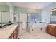 Bright bathroom featuring a tub, glass-enclosed shower, chandelier, and double sink vanity offering luxurious relaxation at 313 Glenridding St, Las Vegas, NV 89183