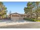 Charming single-story home with a three-car garage, well-manicured lawn, and mature trees at 313 Glenridding St, Las Vegas, NV 89183