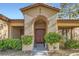 Charming front entrance features an arched entryway and manicured landscaping at 313 Glenridding St, Las Vegas, NV 89183
