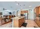 Open-concept kitchen featuring granite countertops, a center island, stainless steel appliances, and seamless flow to dining area at 313 Glenridding St, Las Vegas, NV 89183