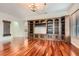 Spacious living room showcasing beautiful hardwood floors, a custom built-in entertainment center, and bright, natural light at 313 Glenridding St, Las Vegas, NV 89183