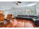 Open-concept living space featuring hardwood floors, bright windows, a fireplace, and a seamless flow to the kitchen area at 313 Glenridding St, Las Vegas, NV 89183