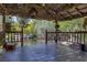 Covered patio offering stunning views of the lush backyard pond with mature trees and rock features at 3330 Wedo Way, North Las Vegas, NV 89031