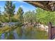 Picturesque view of a serene backyard pond with rock features and lush greenery creating a tranquil oasis at 3330 Wedo Way, North Las Vegas, NV 89031