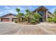 Exterior view of home with a 3-car garage, palm trees and large driveway at 3330 Wedo Way, North Las Vegas, NV 89031