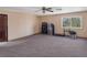 Spacious living room with neutral walls, ceiling fan, carpet, and a large window that provides natural light at 3330 Wedo Way, North Las Vegas, NV 89031