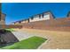 Spacious backyard with gravel, a faux-grass installation, and a brick perimeter wall at 3716 W Colton Ave, North Las Vegas, NV 89032